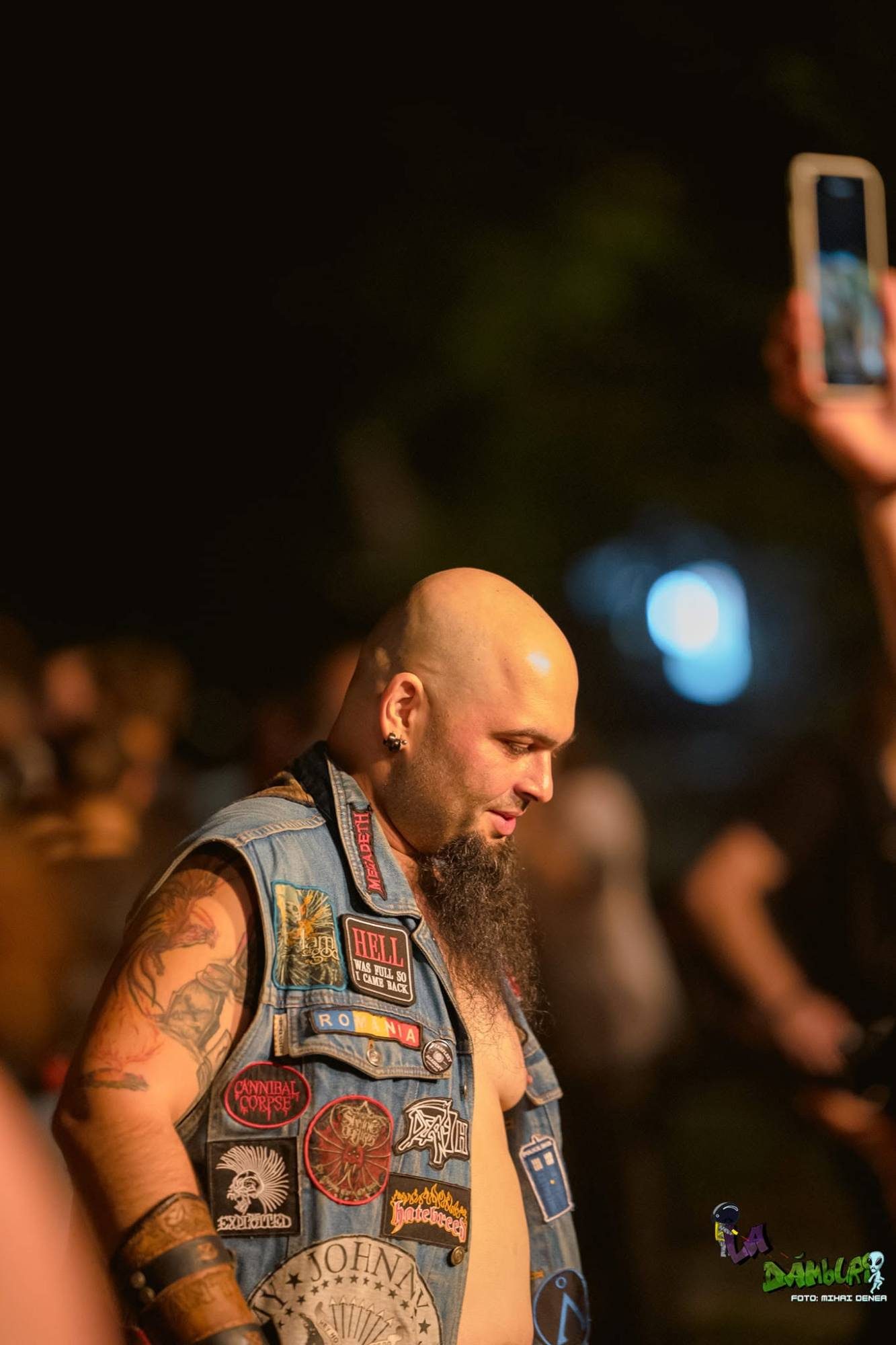 Bărbat cu vestă de blugi și embleme, în mulțime