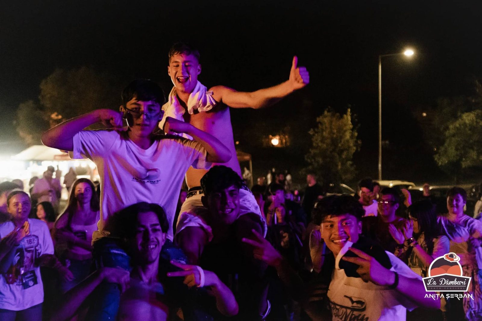 Tineri pe umerii altora într-un concert